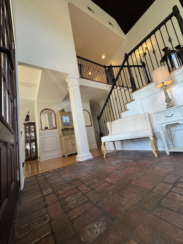 foyer featuring a towering ceiling and decorative columns