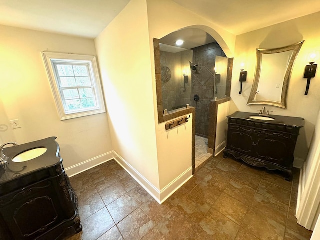 bathroom with vanity and a tile shower