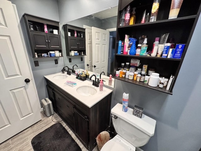 bathroom featuring wood-type flooring, vanity, and toilet