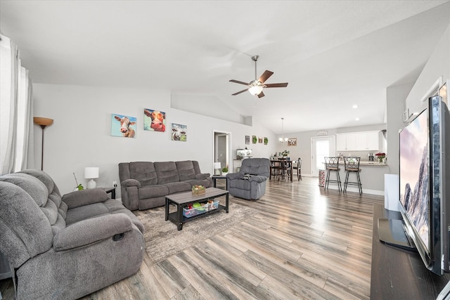 living room featuring vaulted ceiling, ceiling fan, and light hardwood / wood-style floors