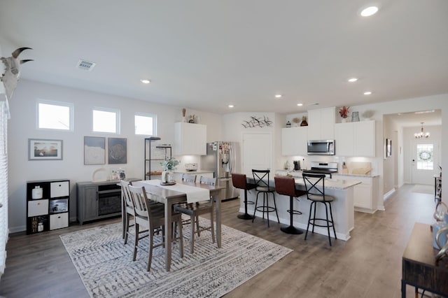 dining area featuring a notable chandelier, hardwood / wood-style floors, and a wealth of natural light