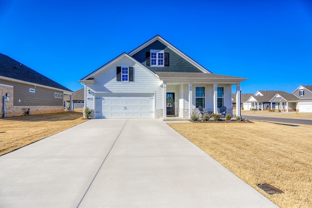 craftsman inspired home featuring a garage, covered porch, and a front lawn