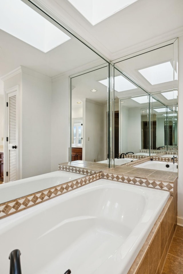 bathroom featuring crown molding, a skylight, tile patterned floors, and tiled bath