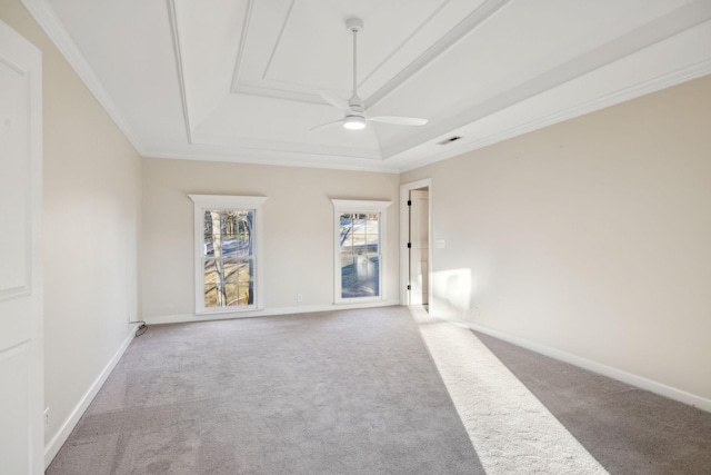 carpeted empty room with a tray ceiling, ornamental molding, and ceiling fan