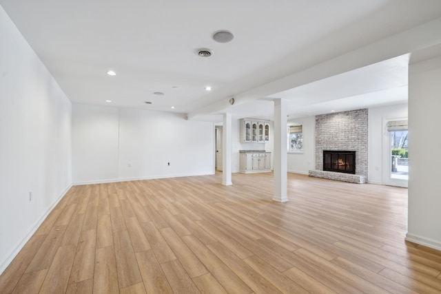 unfurnished living room with a fireplace and light hardwood / wood-style floors