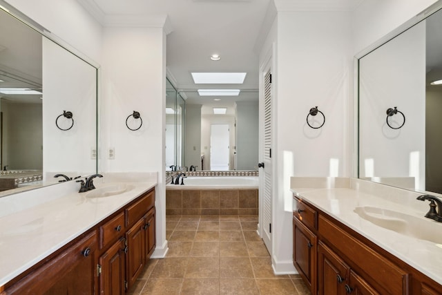 bathroom with tile patterned floors, a skylight, vanity, ornamental molding, and tiled tub