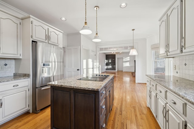 kitchen featuring white cabinetry, stainless steel fridge with ice dispenser, hanging light fixtures, light wood-type flooring, and black electric stovetop