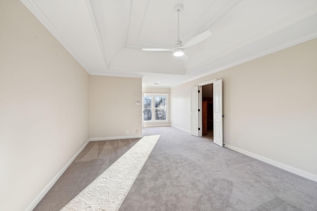 carpeted spare room featuring a tray ceiling, ornamental molding, and ceiling fan