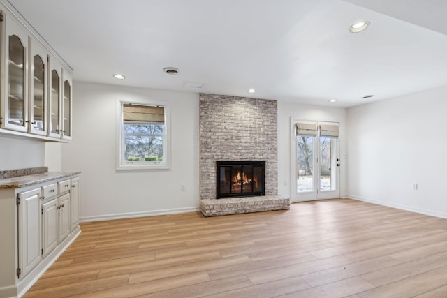 unfurnished living room featuring a fireplace and light hardwood / wood-style flooring