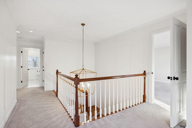 hall featuring ornamental molding, light colored carpet, and an inviting chandelier