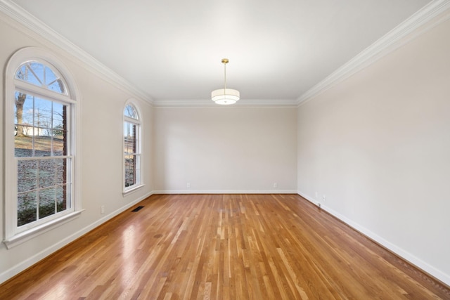 spare room featuring ornamental molding and light wood-type flooring