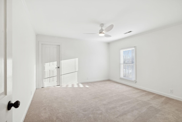 empty room with ornamental molding, light colored carpet, and ceiling fan