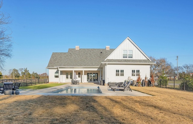 rear view of house featuring a fenced in pool, a lawn, and a patio