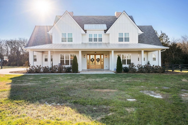 modern farmhouse with french doors, covered porch, and a front yard