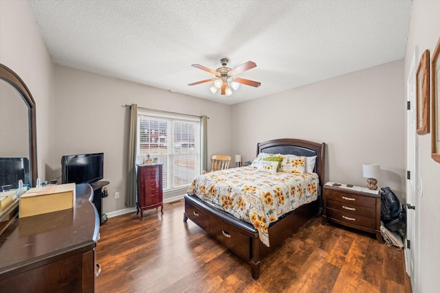 bedroom featuring dark wood-type flooring, a textured ceiling, and ceiling fan