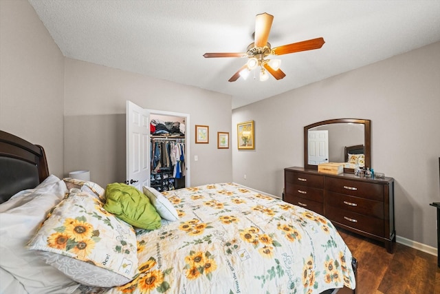 bedroom featuring ceiling fan, dark hardwood / wood-style floors, a closet, and a walk in closet