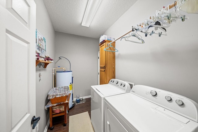 washroom featuring water heater, washing machine and dryer, dark hardwood / wood-style floors, and a textured ceiling