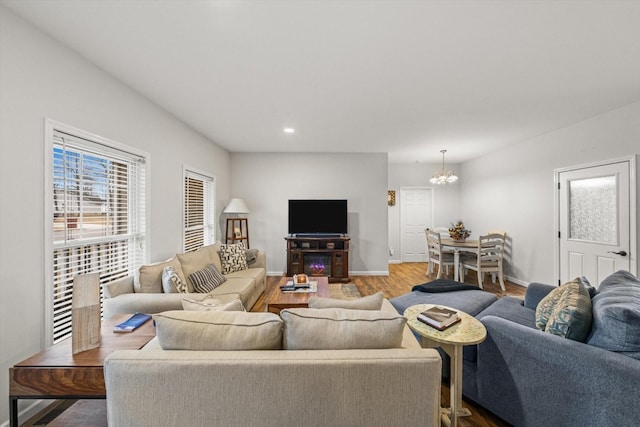 living room featuring a notable chandelier and light hardwood / wood-style flooring