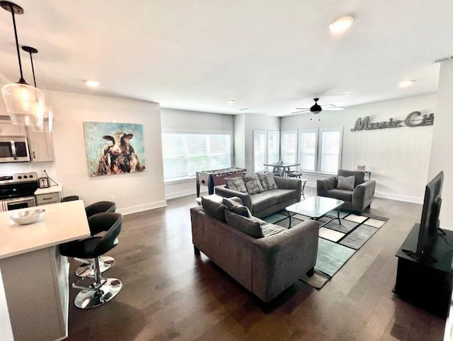 living room featuring plenty of natural light, dark wood-type flooring, and ceiling fan