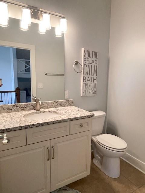 bathroom with tile patterned flooring, vanity, and toilet