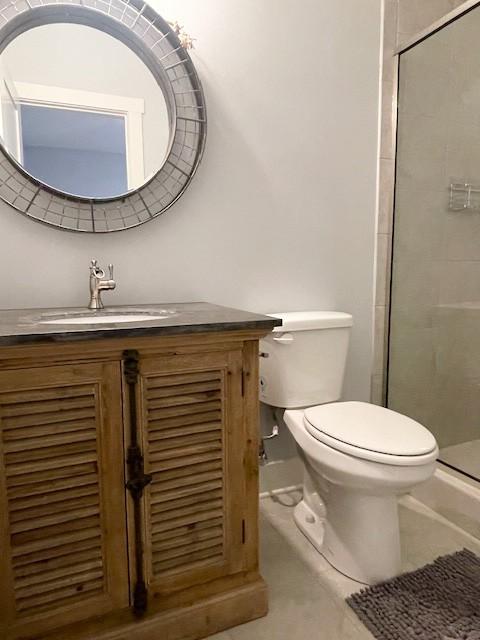 bathroom with vanity, an enclosed shower, and toilet