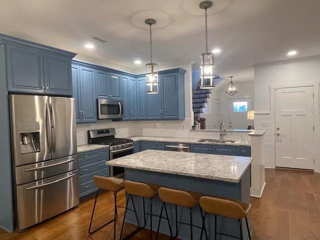 kitchen featuring blue cabinets, sink, appliances with stainless steel finishes, dark hardwood / wood-style flooring, and a kitchen island