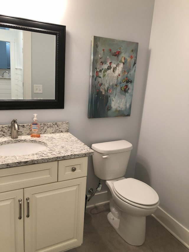 bathroom featuring tile patterned flooring, vanity, and toilet