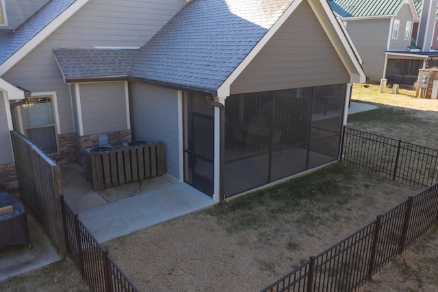 rear view of property featuring a sunroom and a lawn