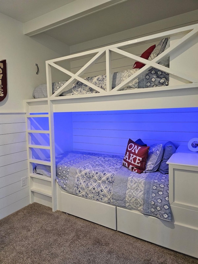 unfurnished bedroom featuring carpet floors and wood walls