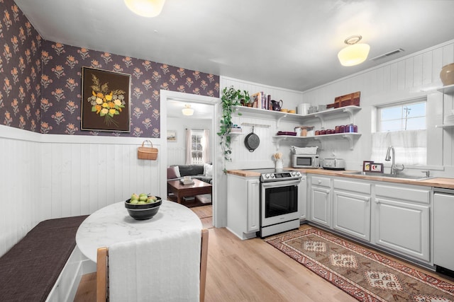 kitchen featuring stainless steel appliances, sink, and light hardwood / wood-style floors