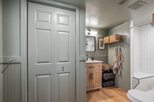 bathroom with vanity, wood-type flooring, toilet, and a shower