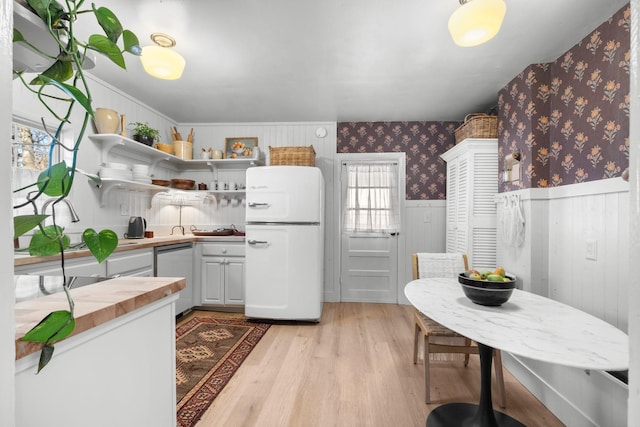 kitchen with white refrigerator, dishwasher, and light wood-type flooring