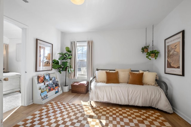 bedroom featuring ensuite bathroom and light hardwood / wood-style floors