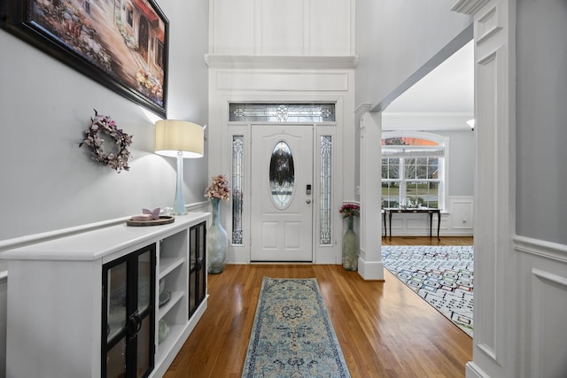 entrance foyer featuring hardwood / wood-style flooring and crown molding