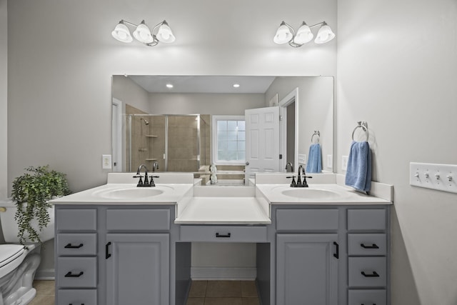 bathroom featuring an enclosed shower, vanity, tile patterned flooring, and toilet