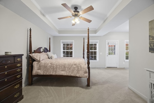 carpeted bedroom featuring crown molding, a raised ceiling, and ceiling fan