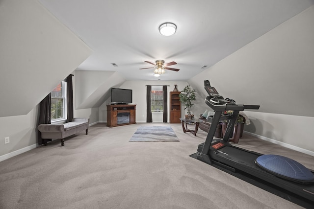 exercise area featuring ceiling fan, lofted ceiling, and carpet floors