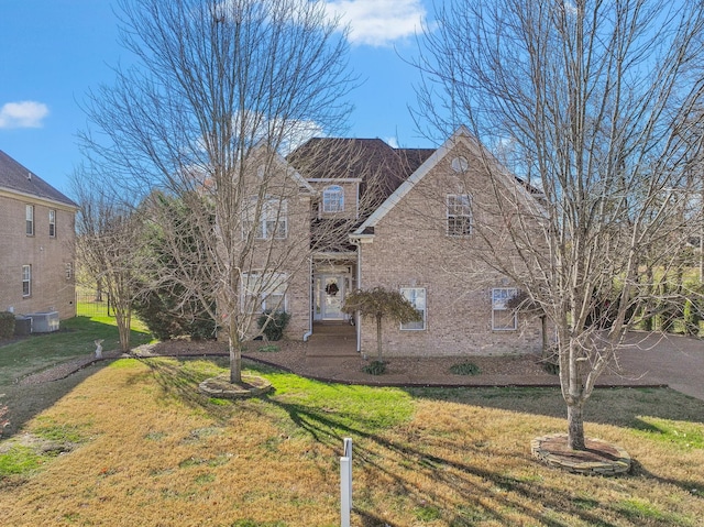 view of front facade featuring a front yard and central AC unit