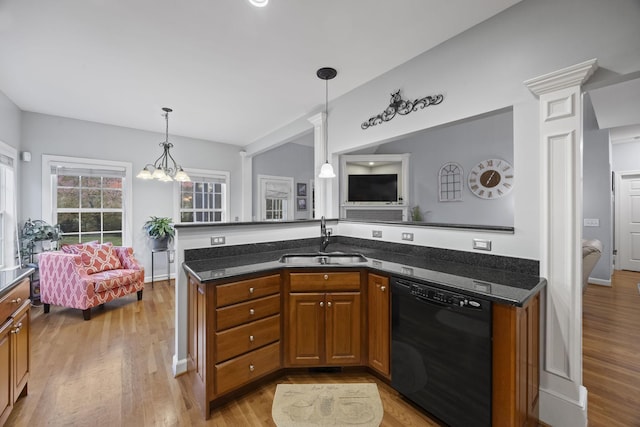 kitchen with sink, light hardwood / wood-style flooring, dishwasher, dark stone countertops, and hanging light fixtures