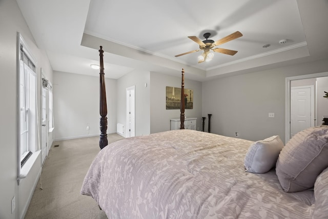 bedroom with light carpet, a tray ceiling, crown molding, and ceiling fan