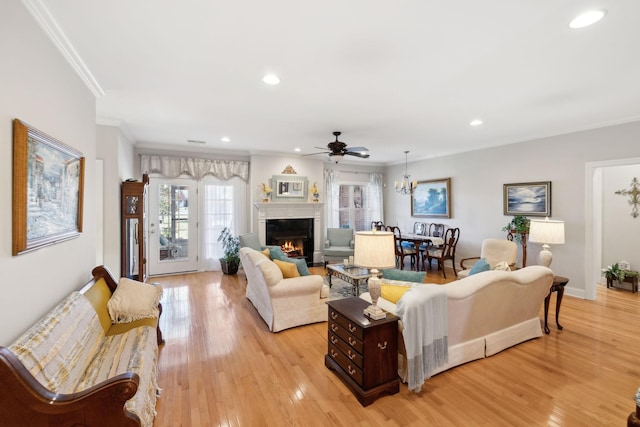 living room featuring crown molding, ceiling fan, and light wood-type flooring