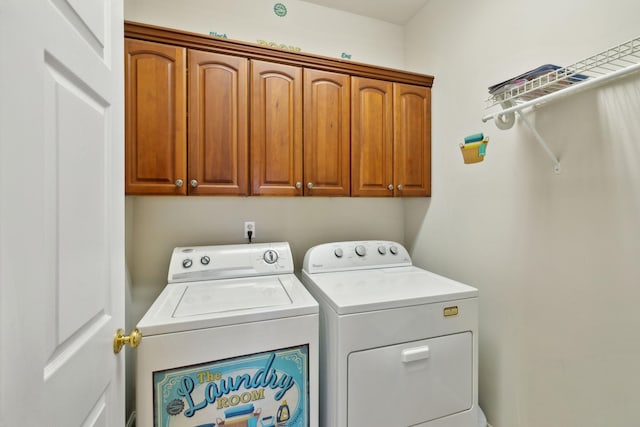 laundry room featuring washing machine and dryer and cabinets