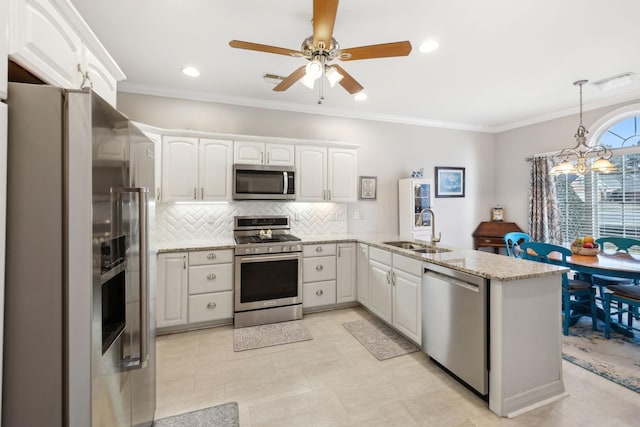 kitchen featuring sink, crown molding, appliances with stainless steel finishes, white cabinetry, and kitchen peninsula