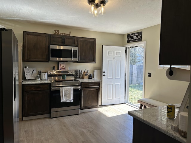 kitchen with stainless steel appliances, light wood-type flooring, and dark brown cabinetry