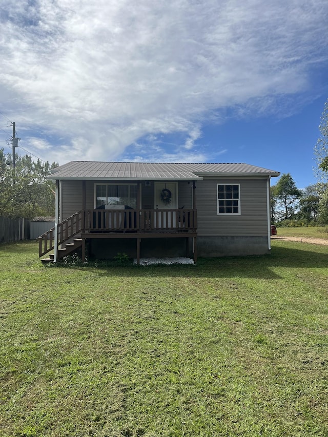 back of property featuring a wooden deck and a lawn