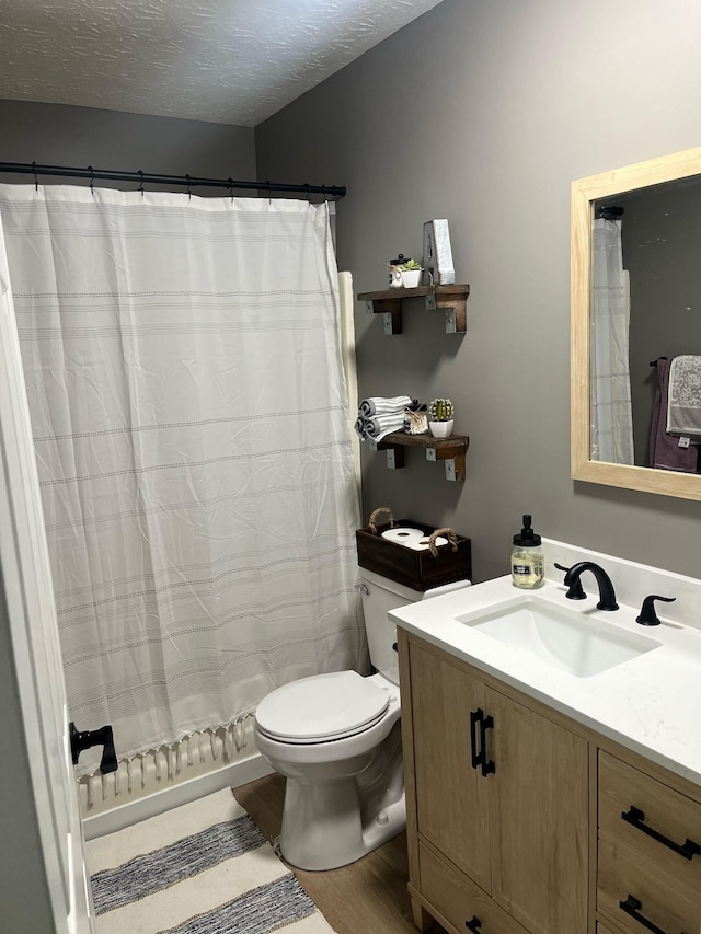 bathroom with hardwood / wood-style floors, vanity, toilet, a textured ceiling, and a shower with curtain