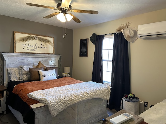 bedroom featuring ceiling fan, a wall unit AC, and a textured ceiling