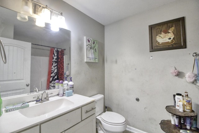 bathroom featuring walk in shower, vanity, and toilet