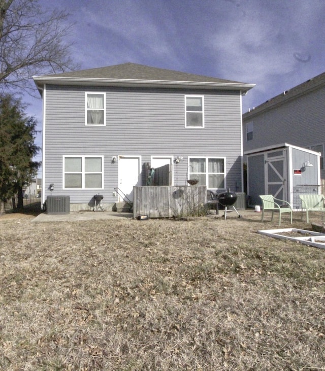 back of house with central AC unit