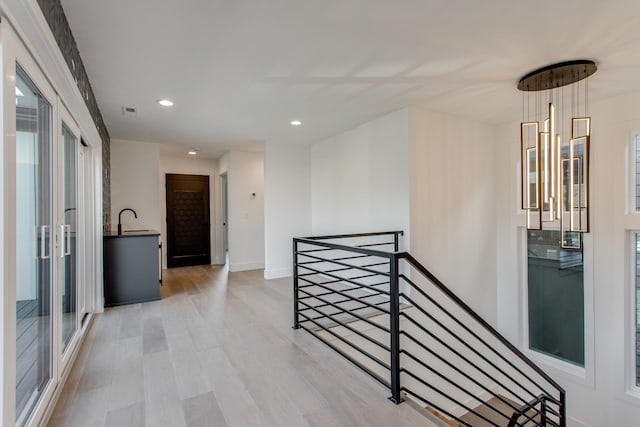 hall with sink and light hardwood / wood-style floors